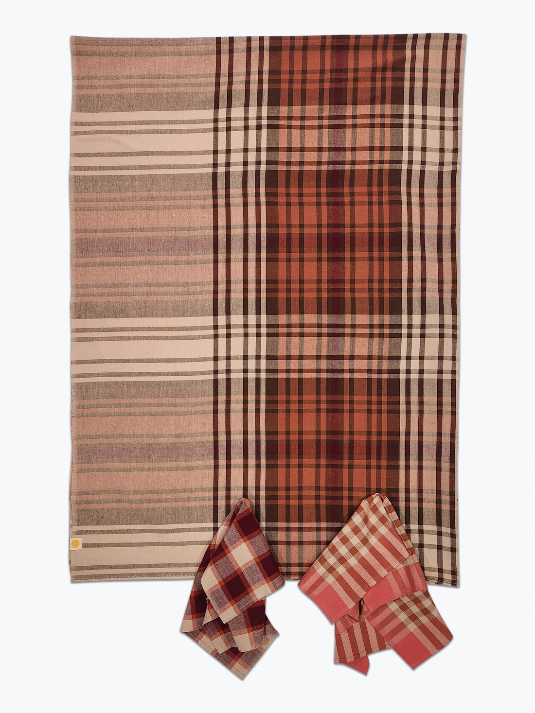 Plaid blanket with a pattern of red, brown, and beige colors on a white background.