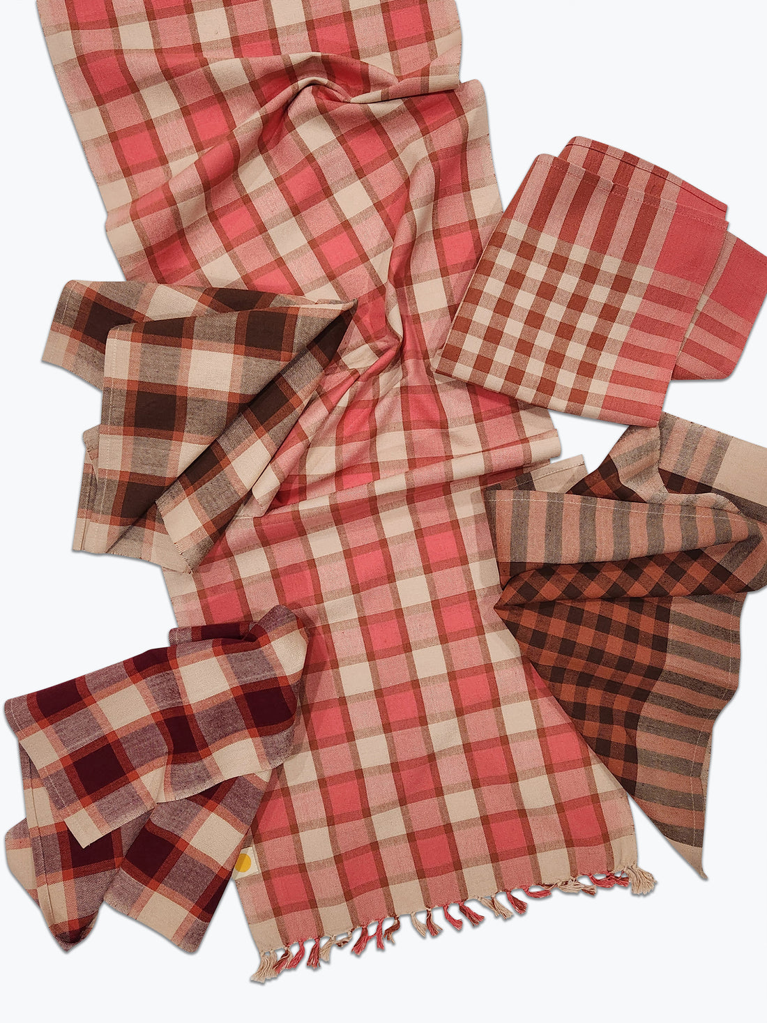 Red and beige checkered tablecloth with napkins on a white background