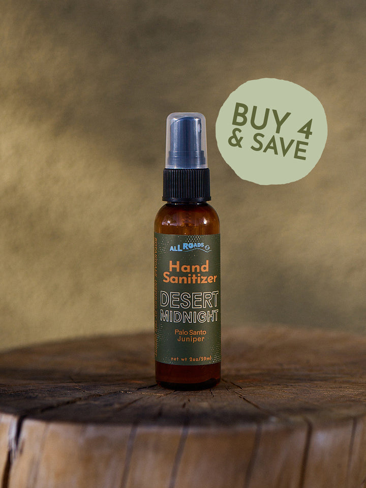 Hand sanitizer bottle labeled 'Desert Midnight' on a wooden surface with a brown background