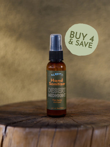 Hand sanitizer bottle labeled 'Desert Midnight' on a wooden surface with a brown background