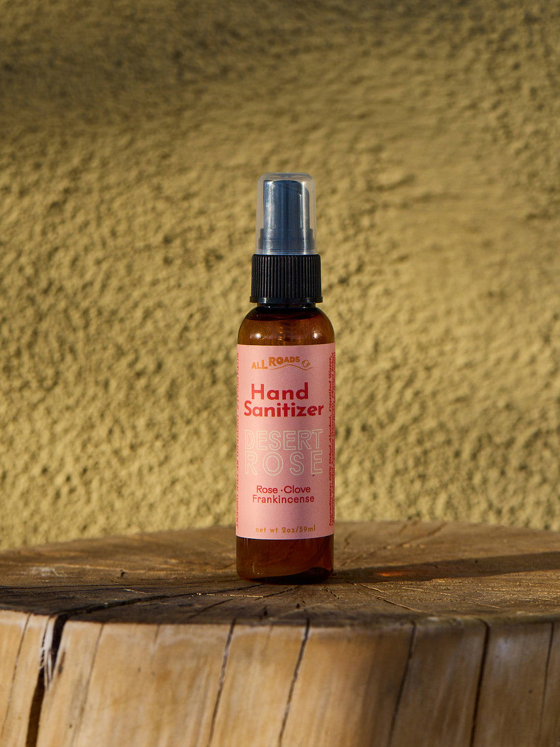 Hand sanitizer bottle on a wooden surface with a textured yellow wall background