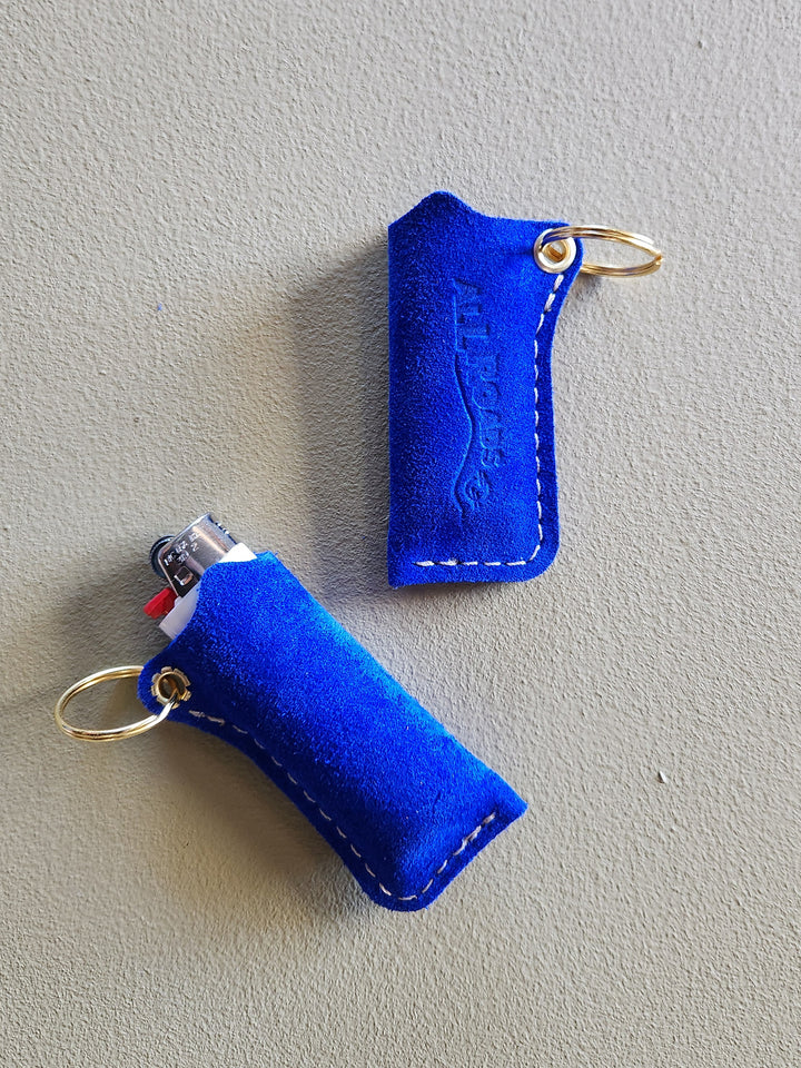 Two blue lighters cases with keychains on a gray background
