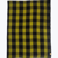 A rectangular woven blanket with a bold buffalo check plaid pattern in olive green and black, shown flat against a light gray background.