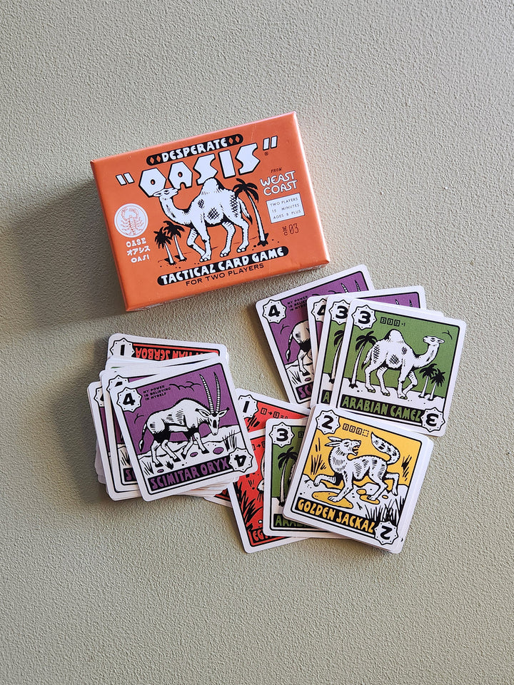 Desert Oasis tactical card game with cards and packaging on a gray surface