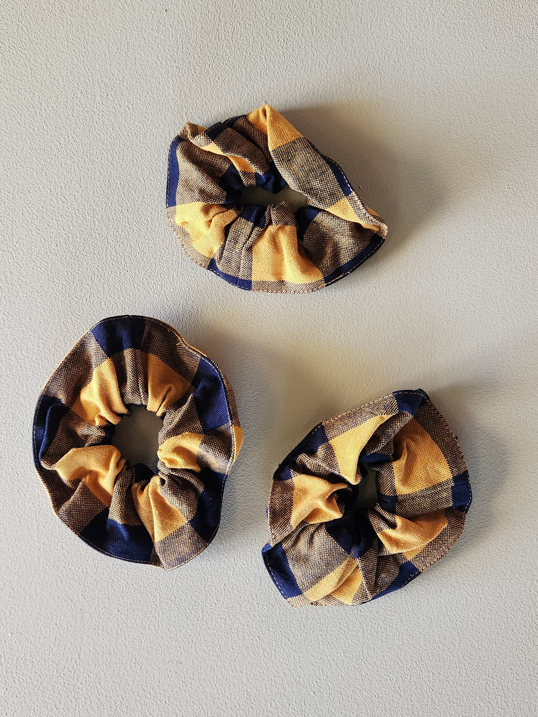 Three plaid scrunchies on a light gray background