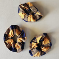 Three plaid scrunchies on a light gray background