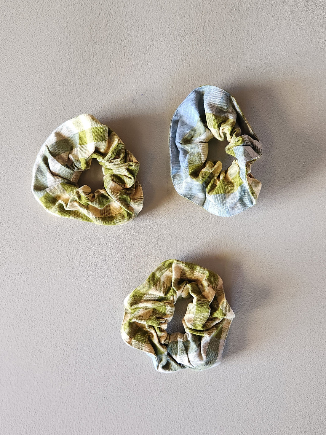 Three plaid scrunchies on a plain background