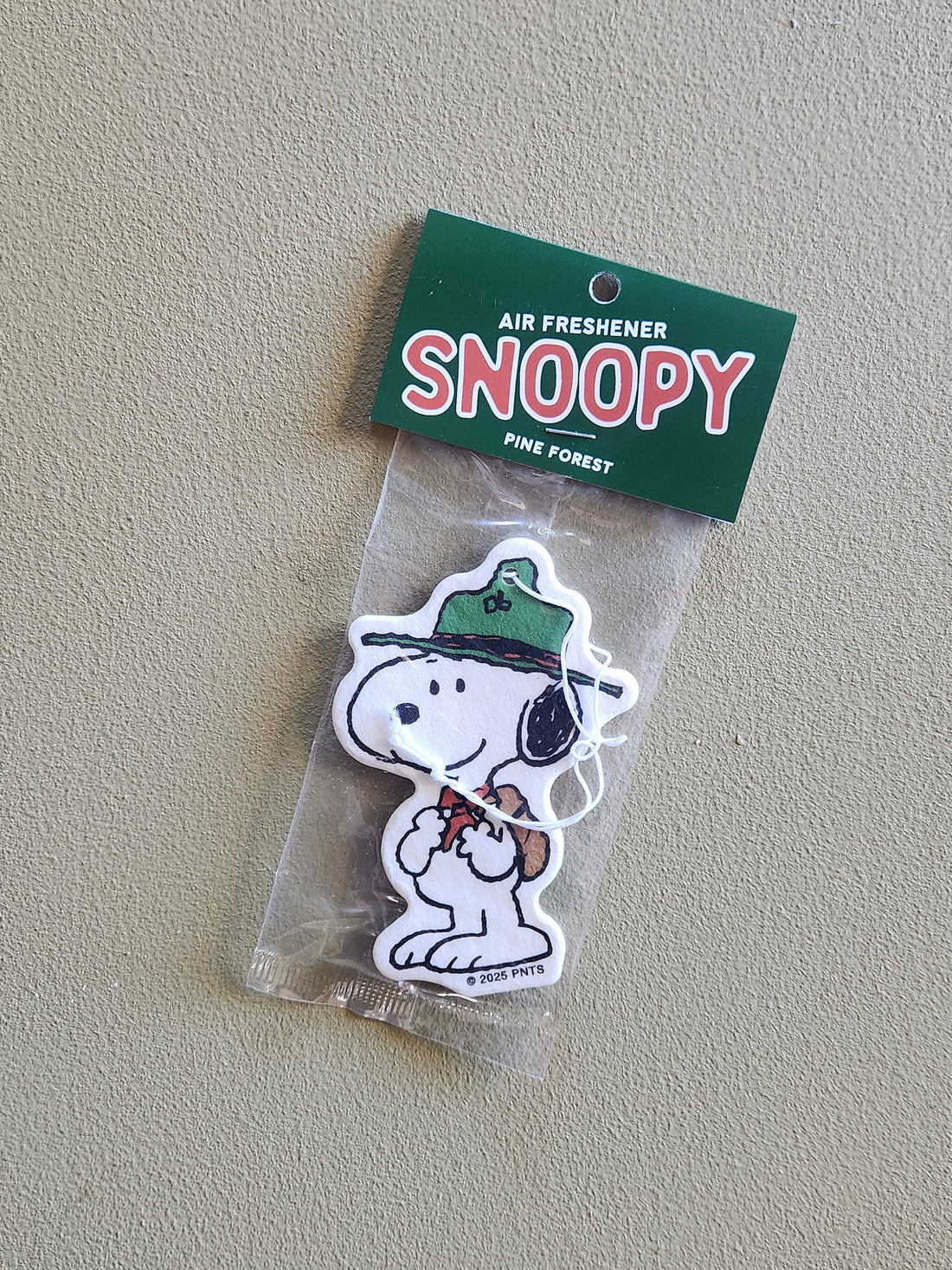 Snoopy air freshener with green hat on a clear background