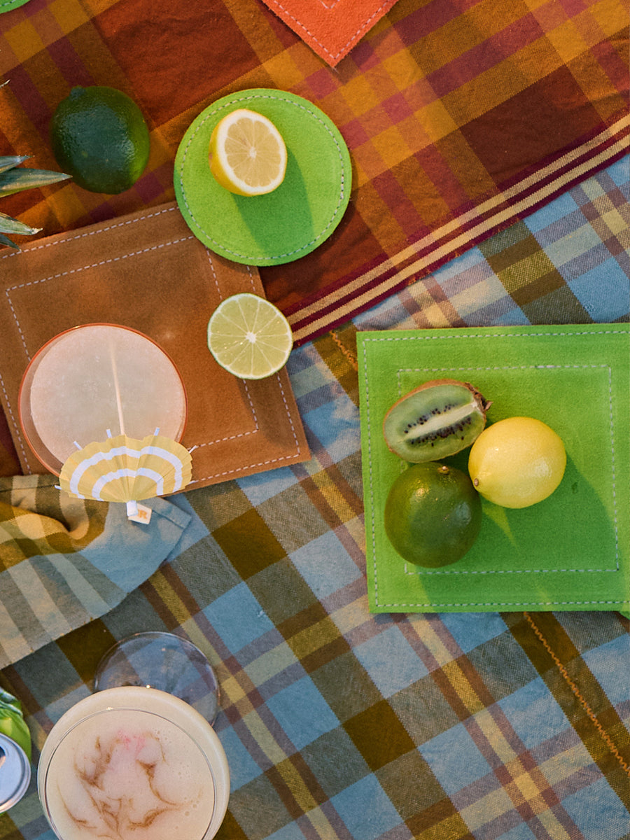 Colorful table setting with fruit and decorative items on a plaid tablecloth