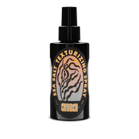 A black spray bottle of Church Sea Salt Texturizing Spray with a black nozzle, featuring a circular label with a tiger-stripe design and gold lettering on a white background.