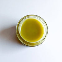 Glass jar with green liquid on a white background