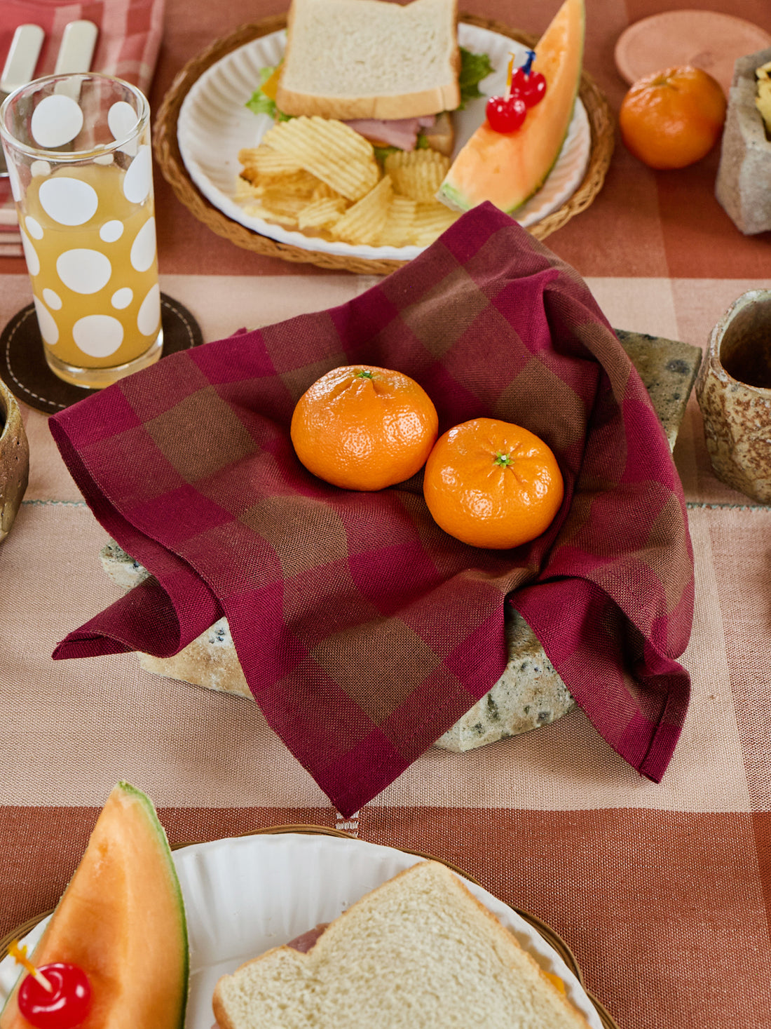 Plated food with oranges on a checkered tablecloth