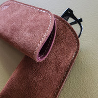 Brown suede pouch with a purple interior on a beige surface