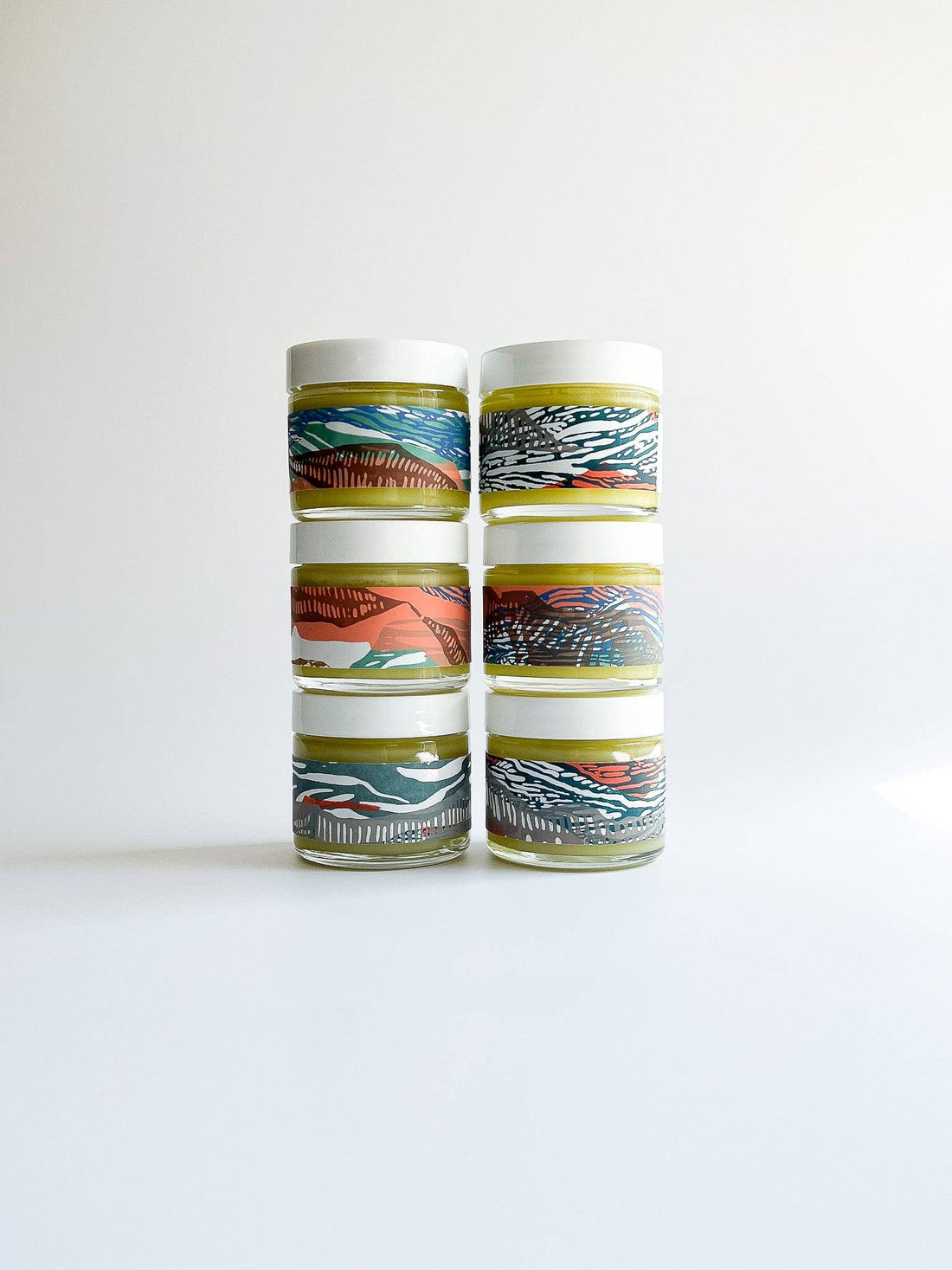 Set of four cylindrical containers with colorful patterns on a white background