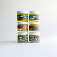 Set of four cylindrical containers with colorful patterns on a white background