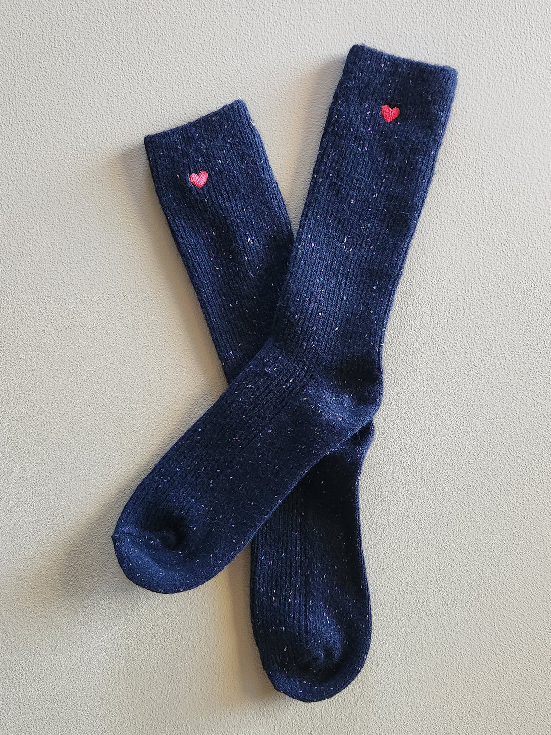 Black socks with small red embroidered hearts on the ankles.
