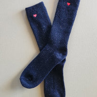 Black socks with small red embroidered hearts on the ankles.