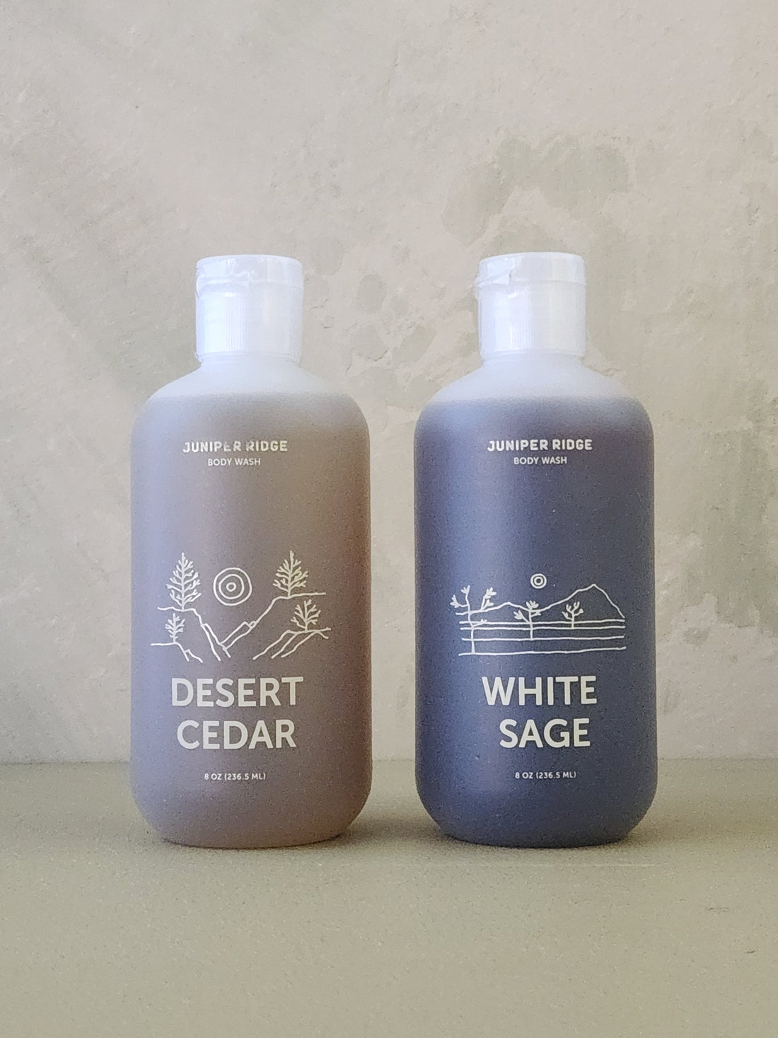 Two bottles of Juniper Ridge body wash, one labeled &