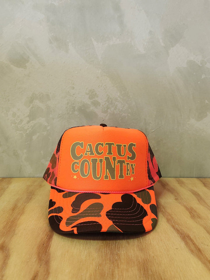 Hi-vis orange camo foam trucker hat with Cactus Country text. 