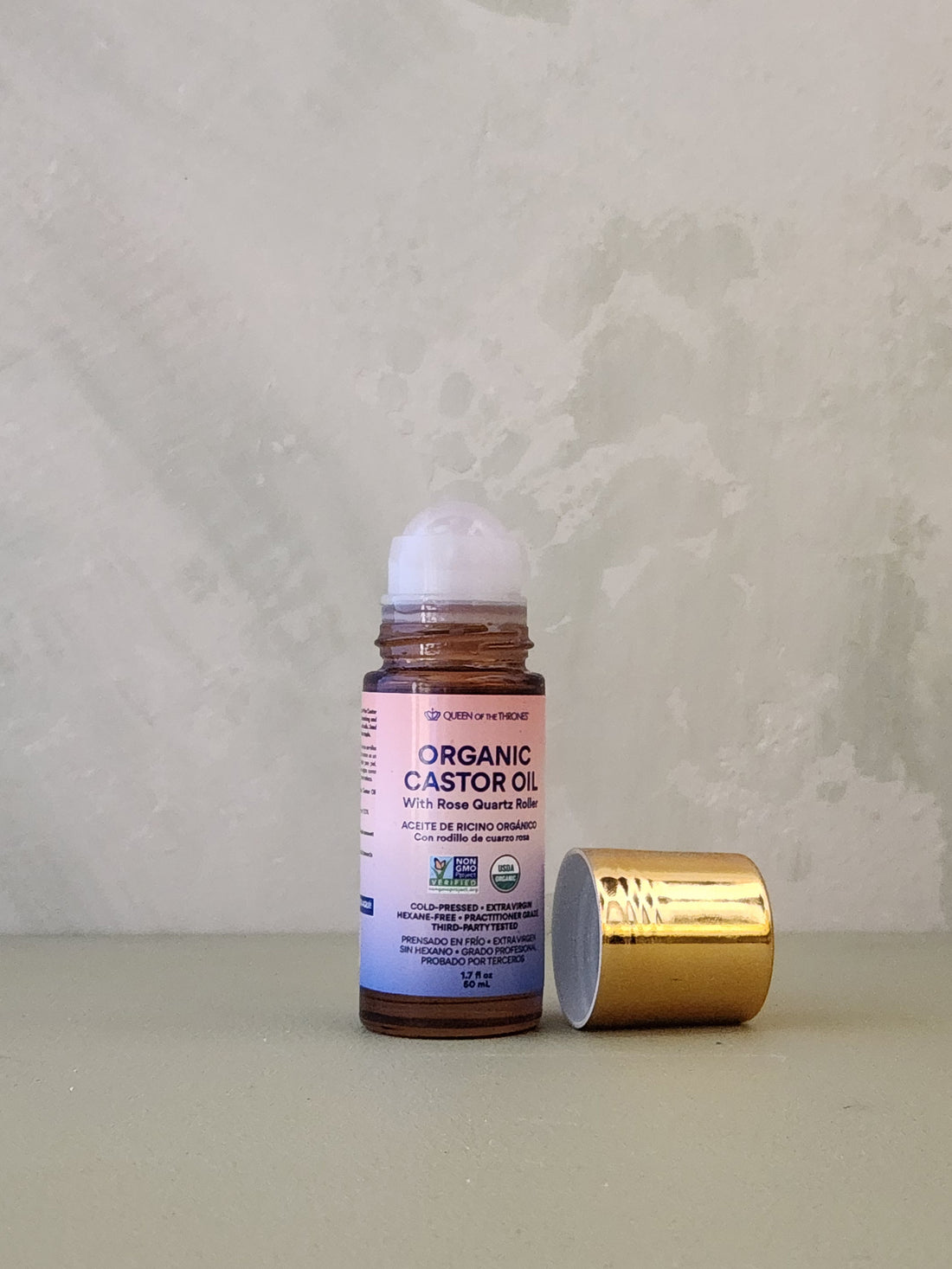 Organic castor oil bottle with gold cap on a textured surface
