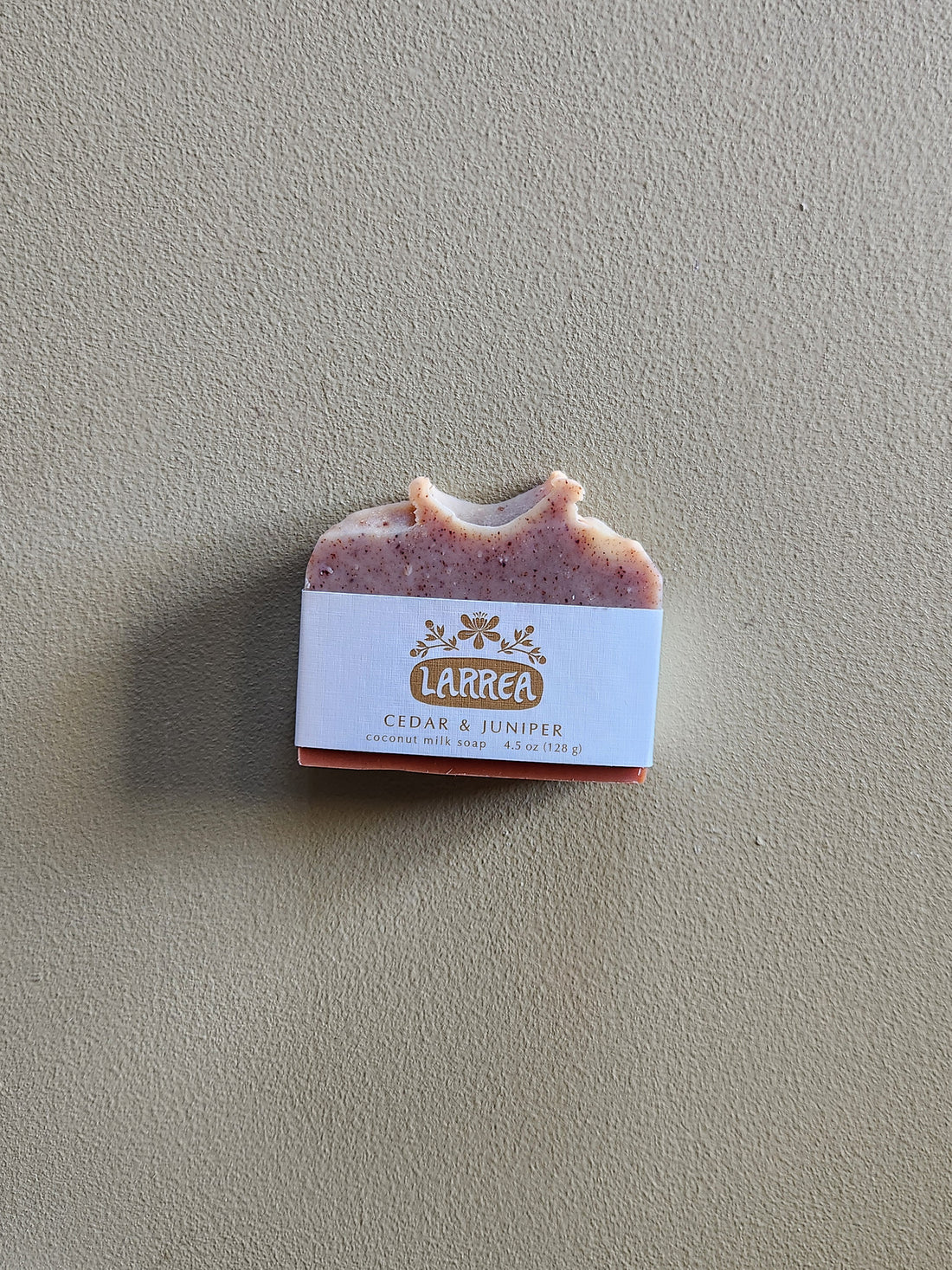 Bar of soap with a Larrea label on a beige background