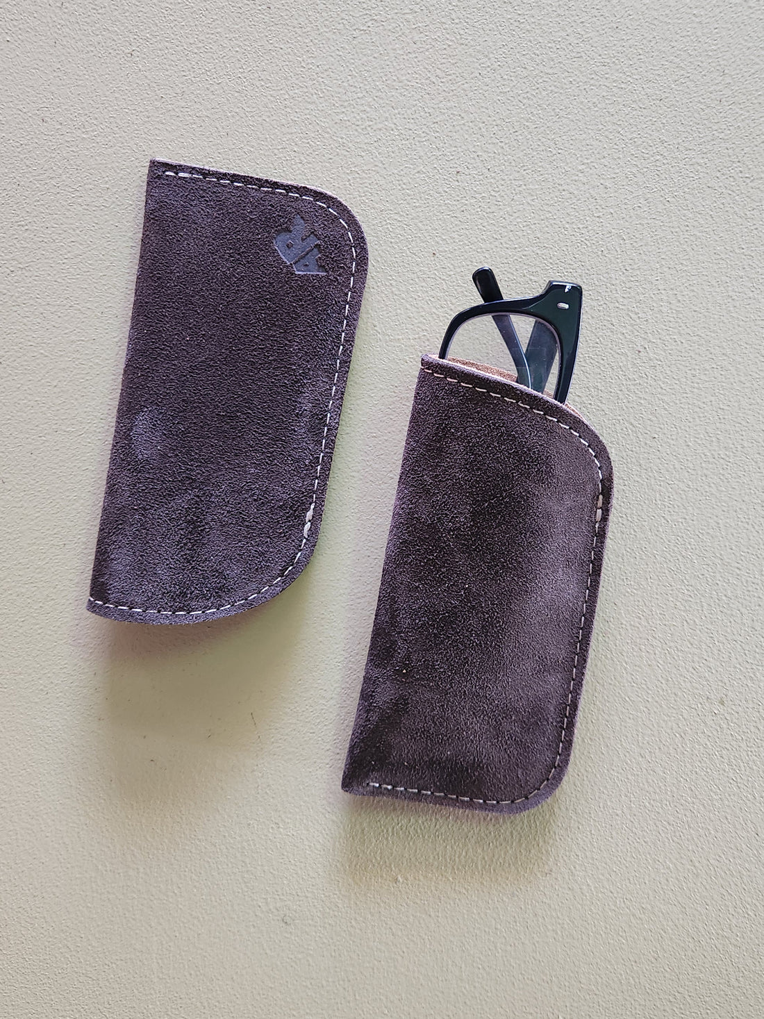 Two purple eyeglass cases on a light gray background