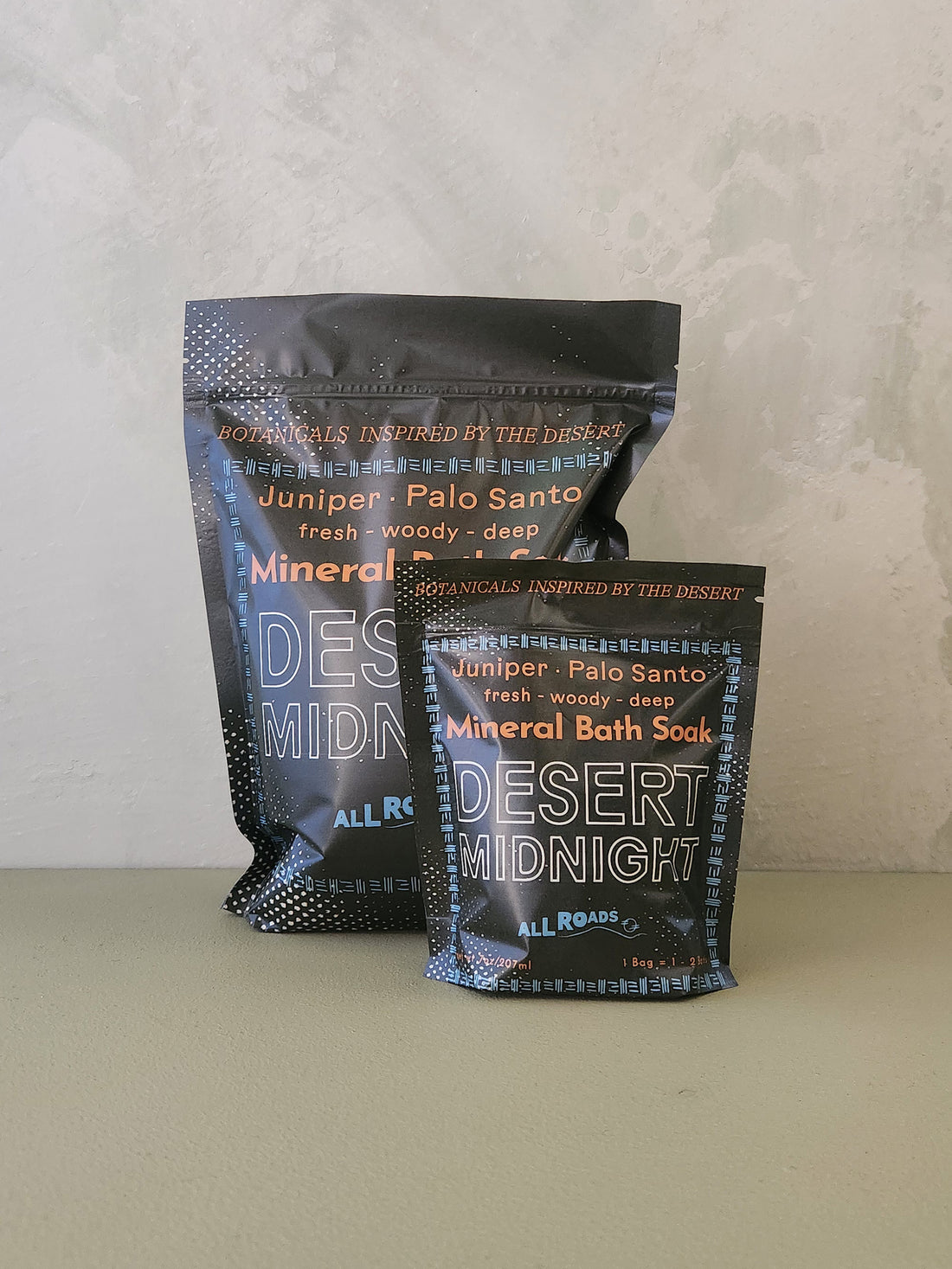 Two packages of Desert Midnight bath soaks on a neutral background