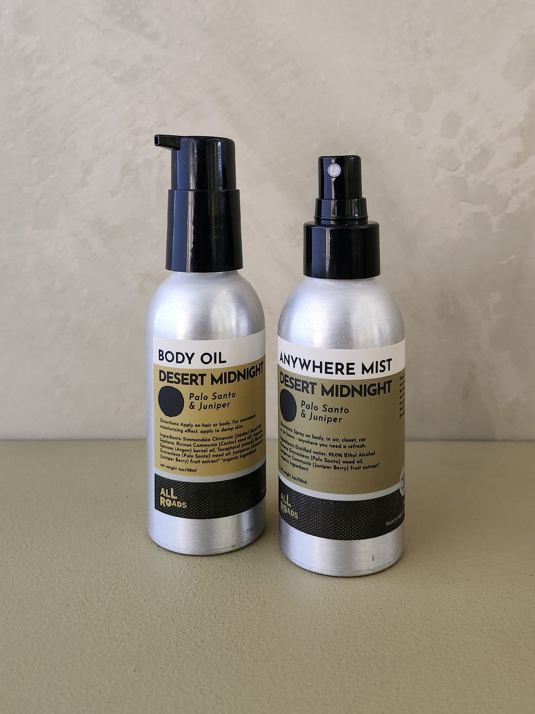 Two bottles of All Roads body and fragrance products, &