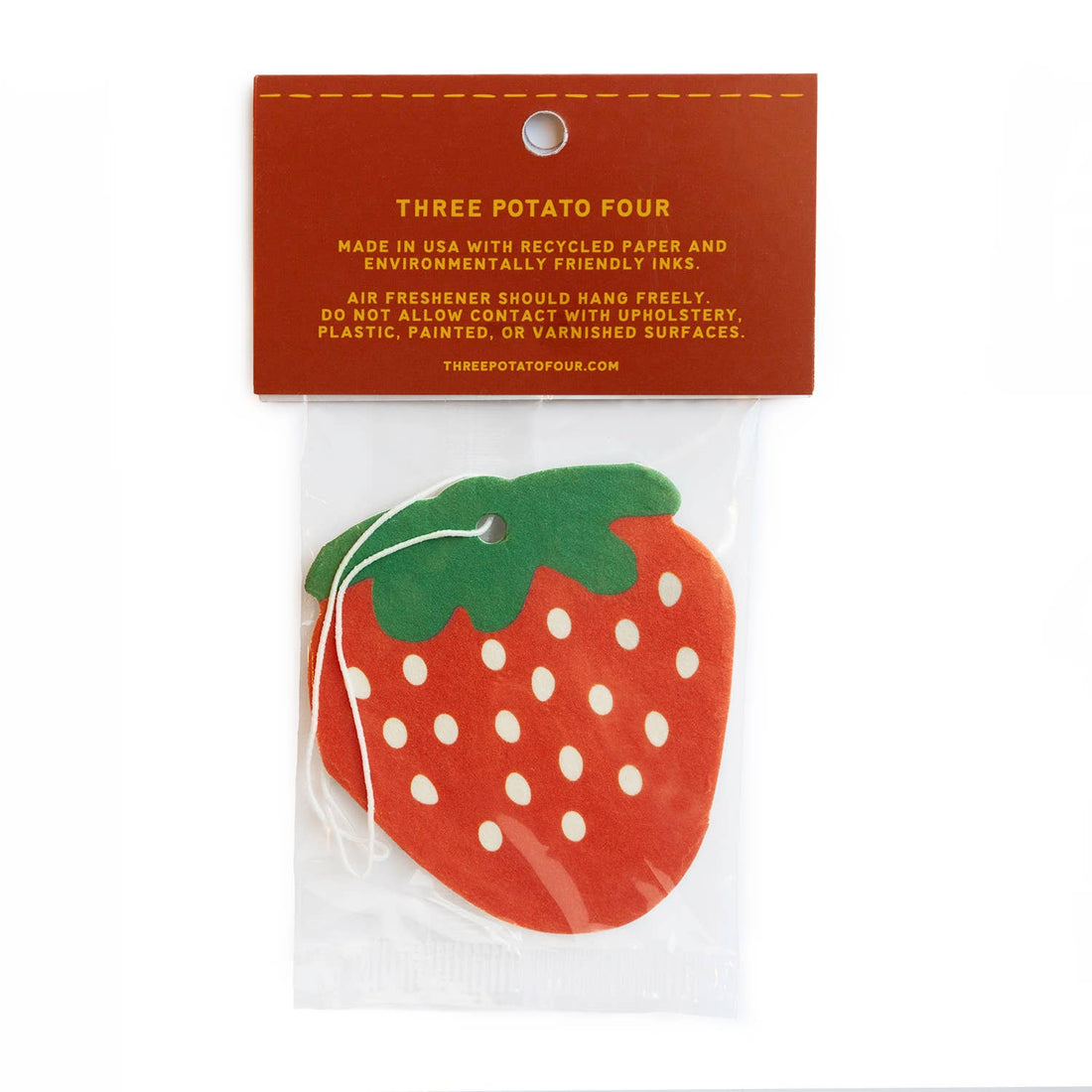 Strawberry-shaped air freshener with a red label on a white background
