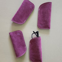 Four purple eyeglass cases on a light gray background