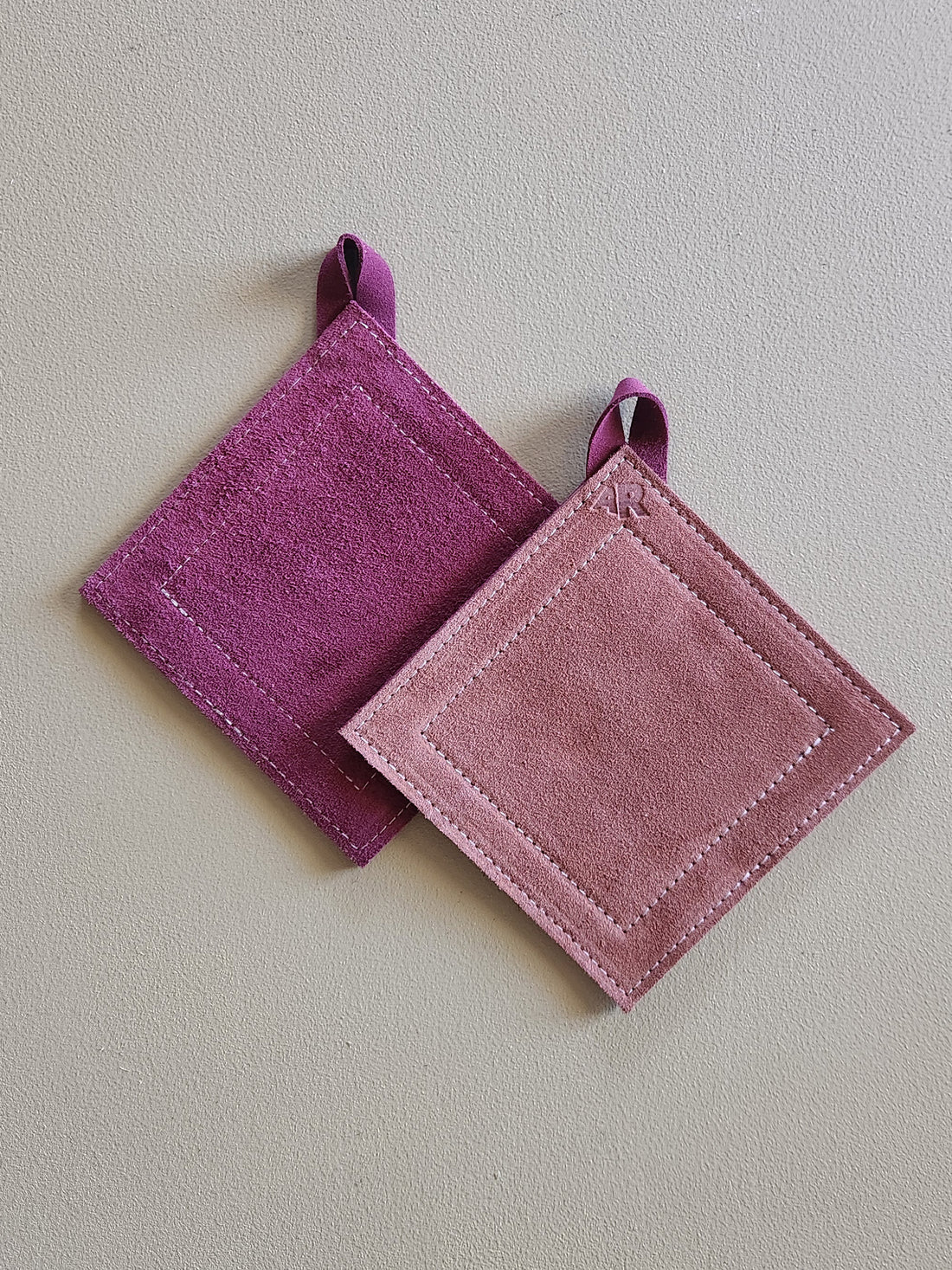 Two purple pot holders on a light gray background