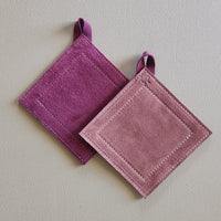 Two purple pot holders on a light gray background