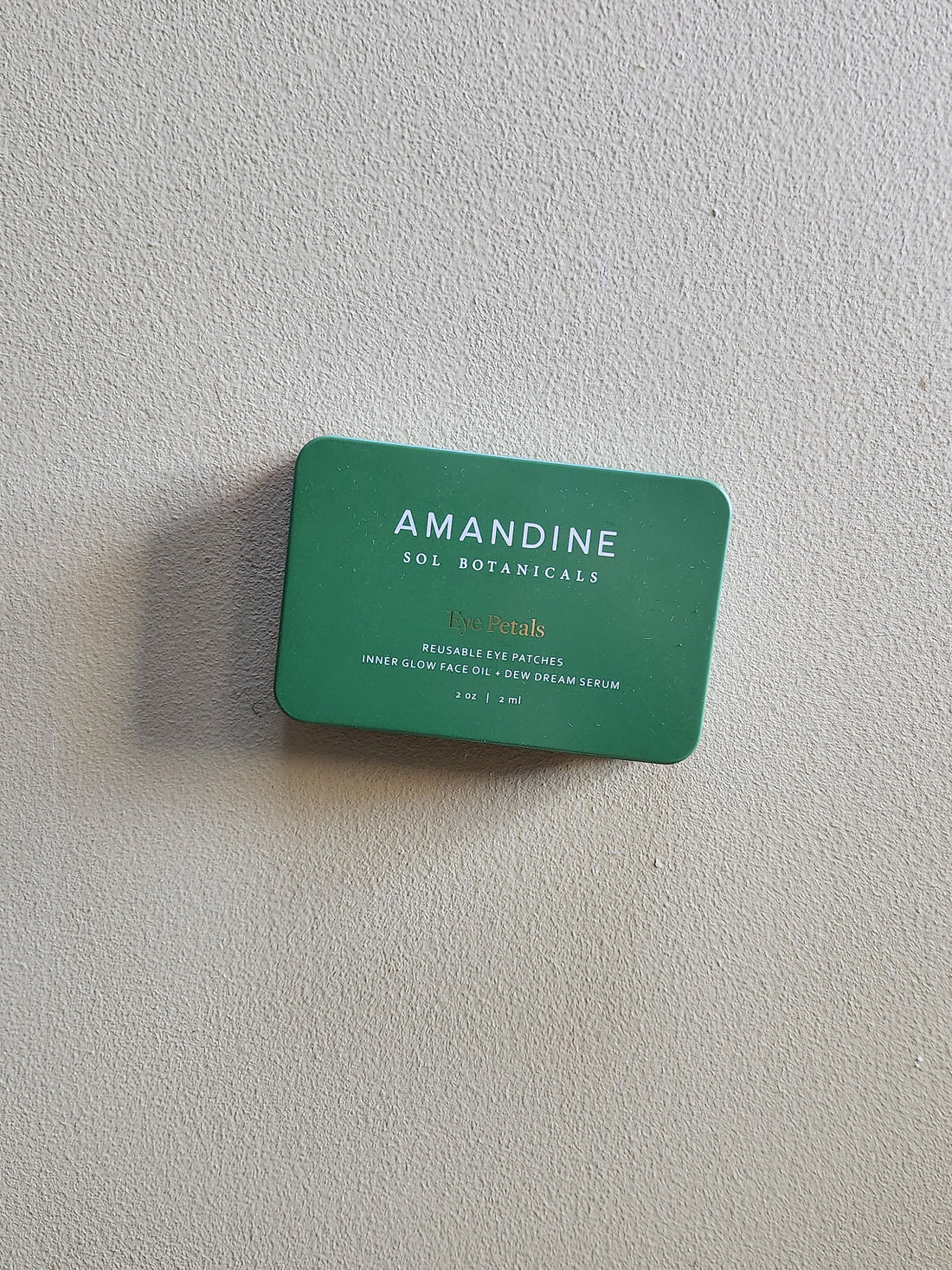 Green Amandine Sol Botanicals product packaging on a light gray background