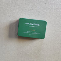 Green Amandine Sol Botanicals product packaging on a light gray background
