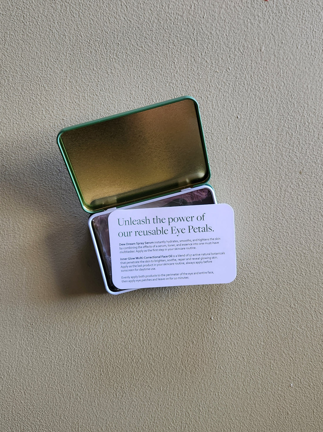 Metallic tin with a card on a beige surface