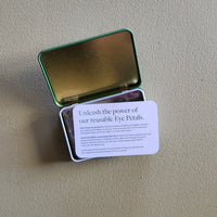 Metallic tin with a card on a beige surface