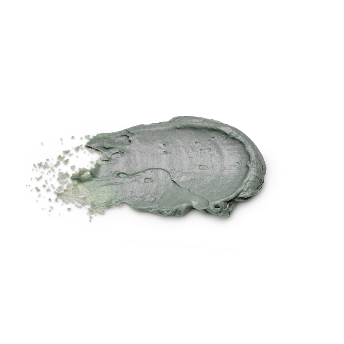 A thick, textured smear of sage green cosmetic cream or clay mask on a solid white background, with fine particles visibly splashing from the left side.