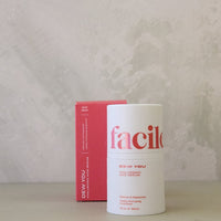 White cylindrical container with 'facile' branding on a light gray surface with a textured white background