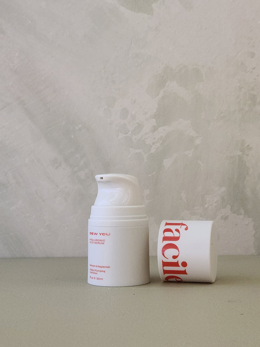 White cream jar with red text on a light gray background