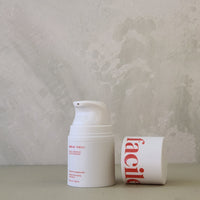White cream jar with red text on a light gray background