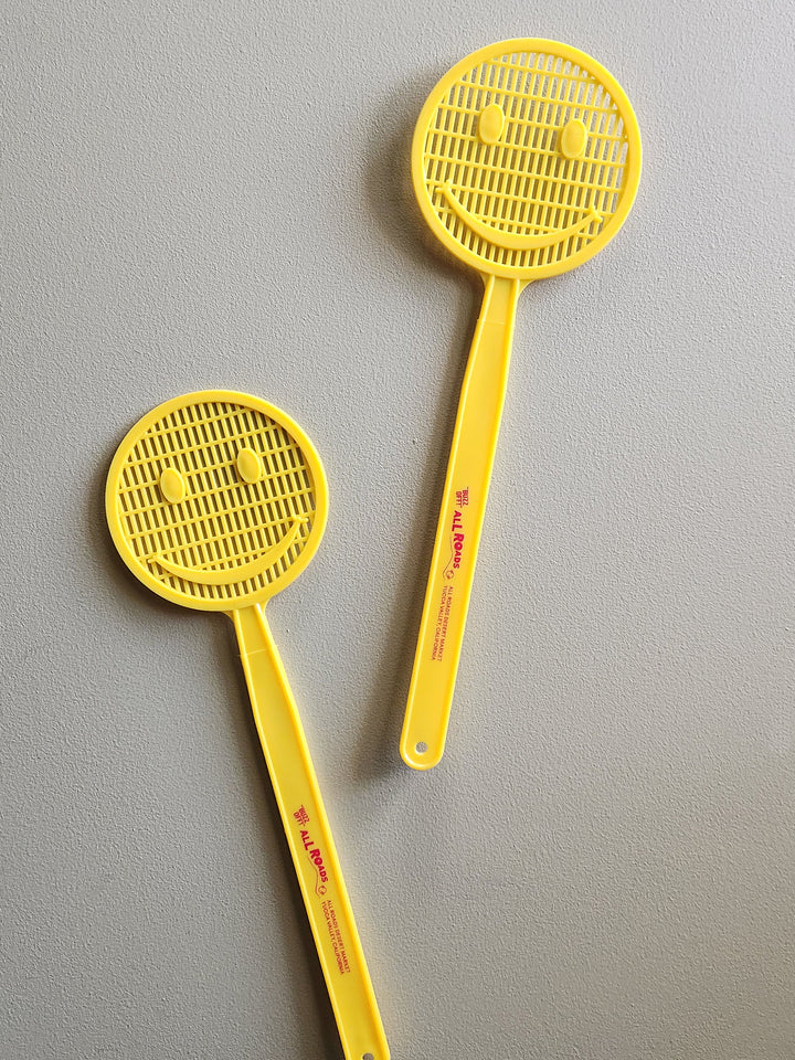 Yellow smiley face fly swatter. 
