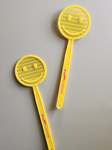 Yellow smiley face fly swatter. 