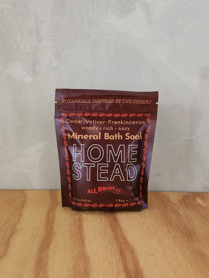 A burgundy pouch of bath salts scented with cedar, vetiver and frankincense essential oils.