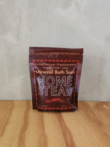 A burgundy pouch of bath salts scented with cedar, vetiver and frankincense essential oils.