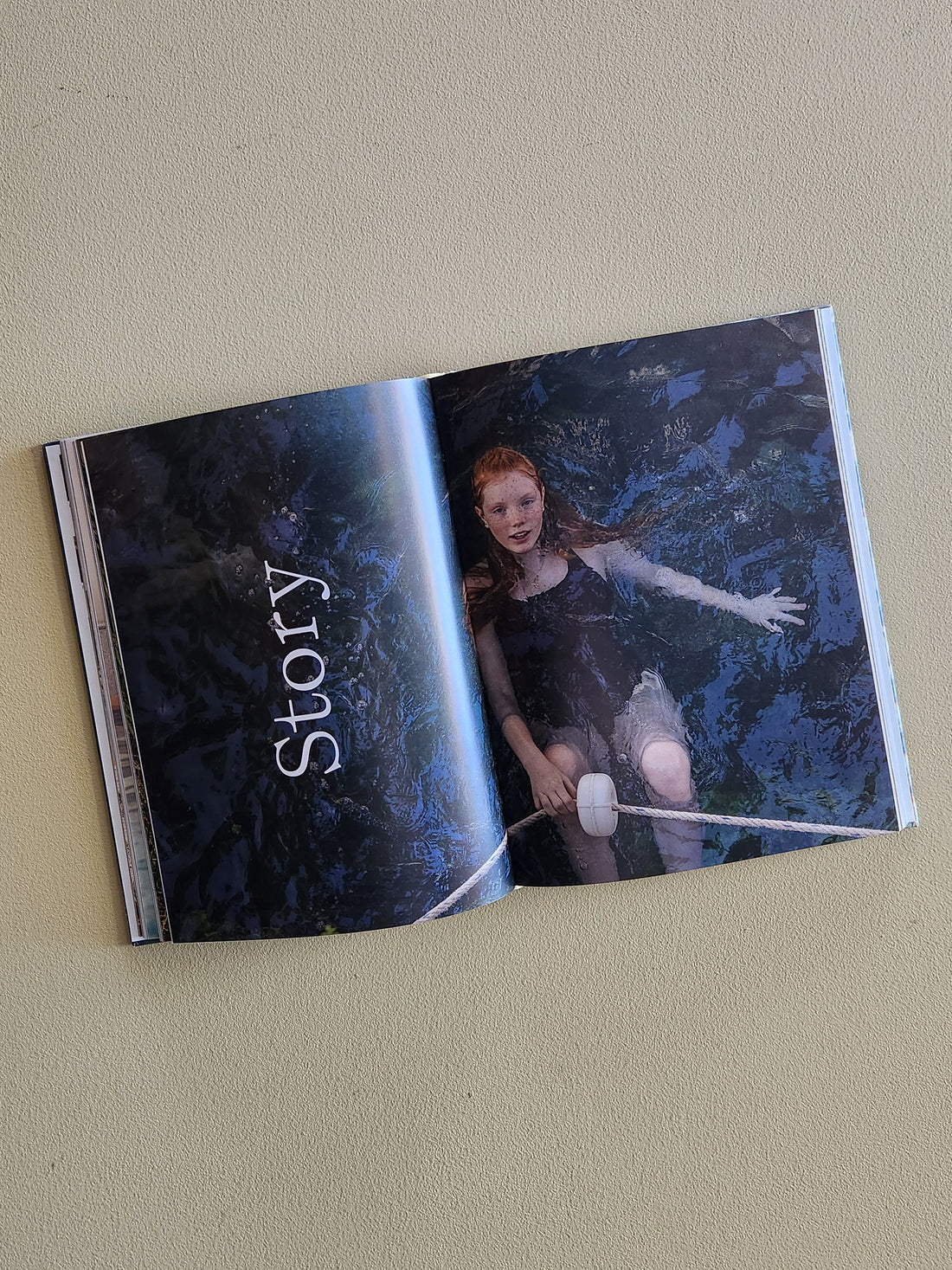 Open book with a dark, artistic cover featuring a person and the word &