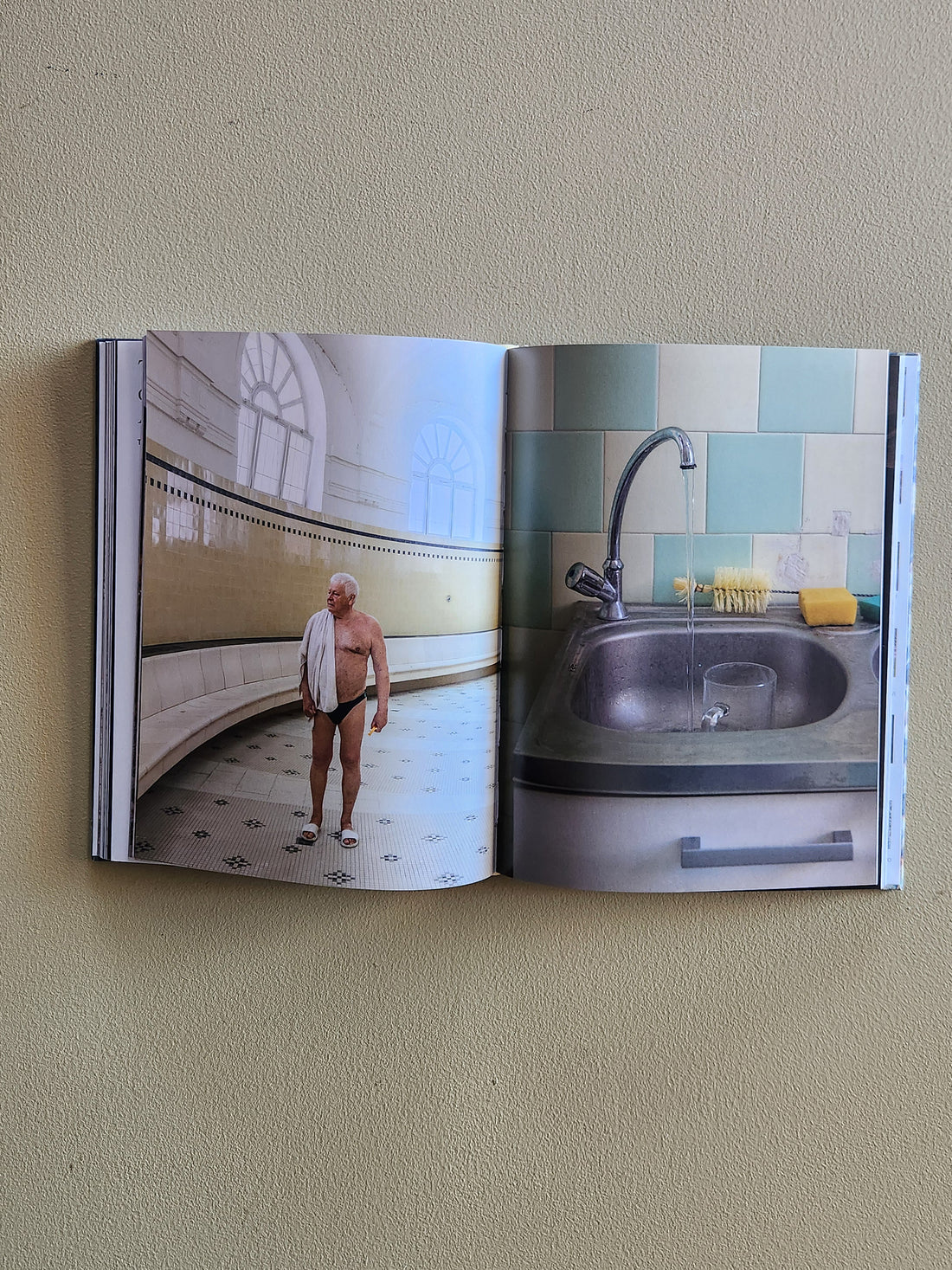 Open book showing a bathroom scene with a man standing in front of a sink.