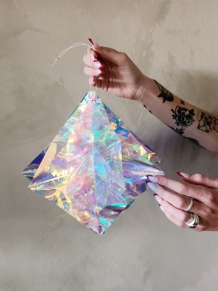 Fold out iridescent star with hanging loop.
