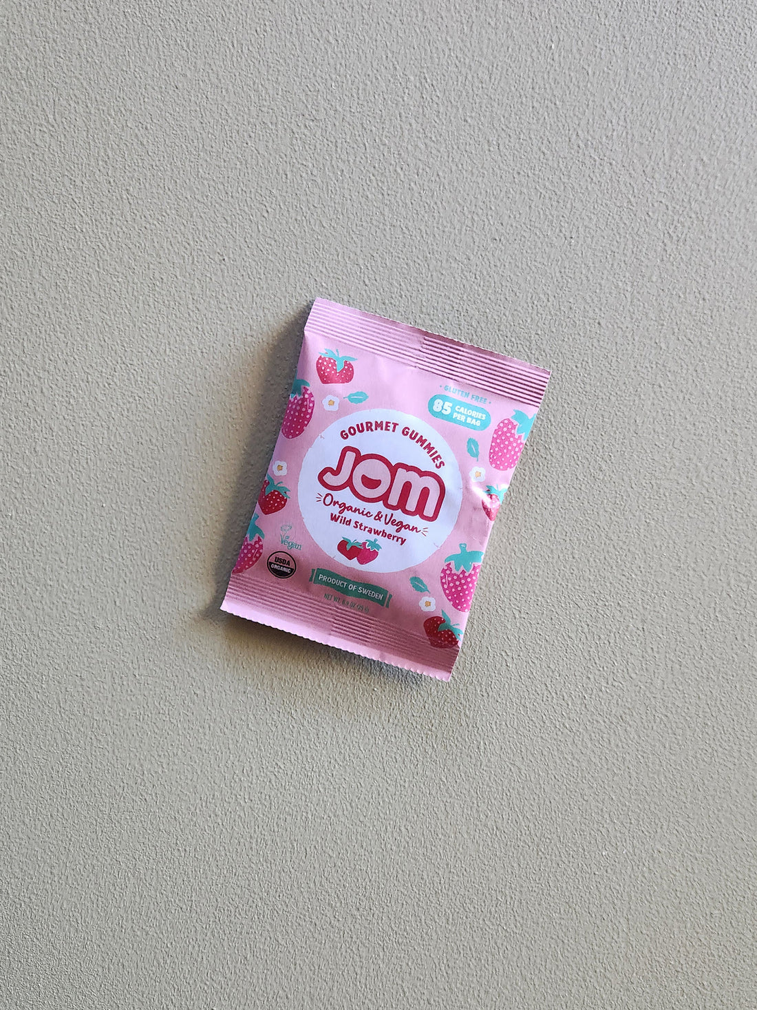 Pink packet of Jom on a gray background
