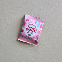 Pink packet of Jom on a gray background