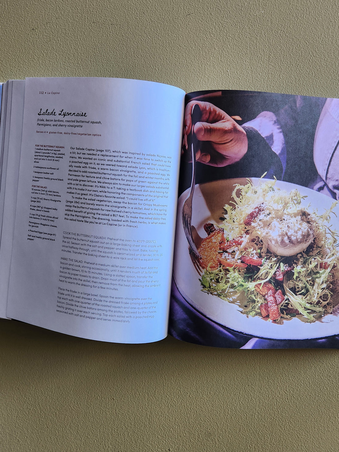 Open book showing a recipe with a photograph of a dish on a green background
